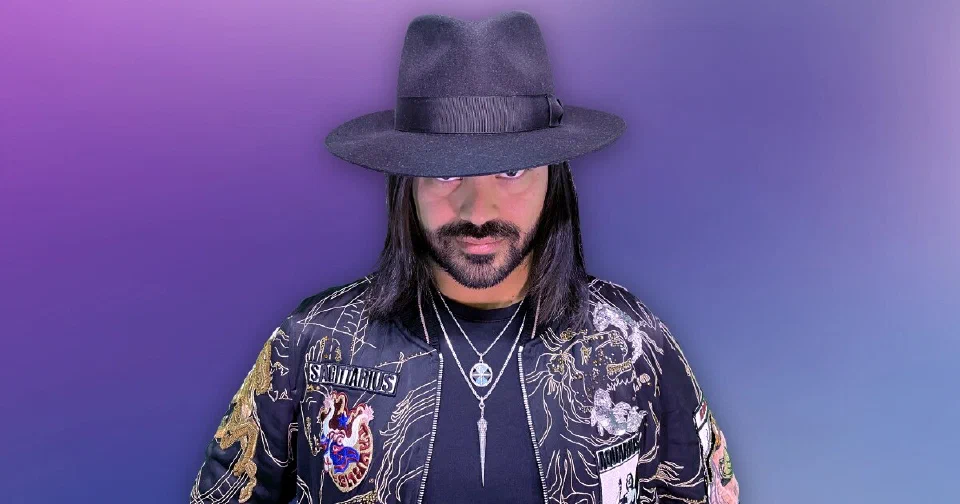 Roshtein in a black fedora and embroidered jacket on a violet background